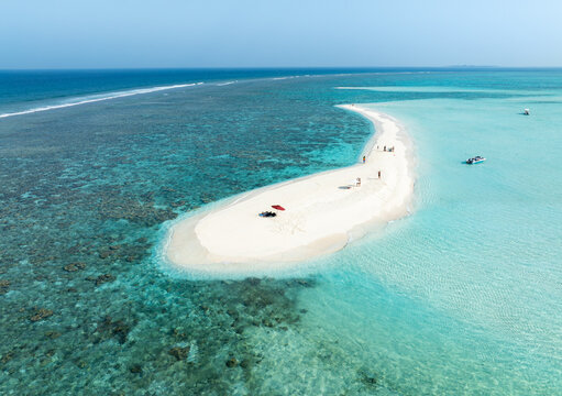 Aerial view of a pristine white sandbank surrounded by turquoise waters and vibrant coral reefs, creating a stunning contrast of colors, Thoddoo, Alif Alif Atoll, Maldives.