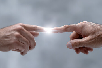 Connection of Two Hands Reaching Toward Each Other with Spark of Light