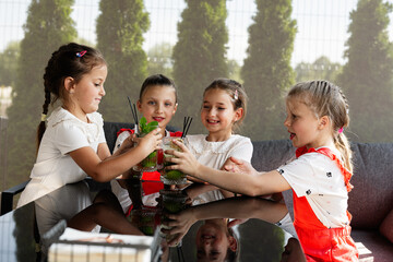 Four young friends enjoy refreshing drinks together at an outdoor gathering