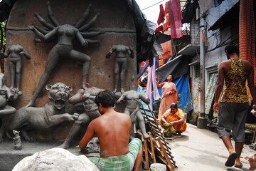 Traditional artisans in Kumartuli, Kolkata crafting exquisite clay idols of Goddess Durga. Ancient Bengali art form showcasing skilled hands shaping sacred sculptures.