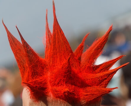 A person with red hair has a red spikey hairstyle