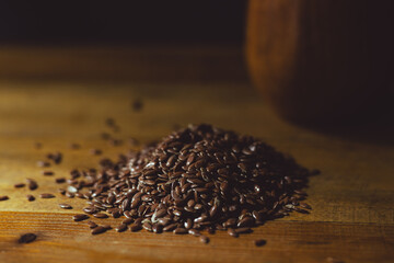 flax seeds in a wooden glass, bowl on a wooden table close-up