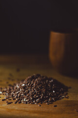 flax seeds in a wooden glass, bowl on a wooden table close-up