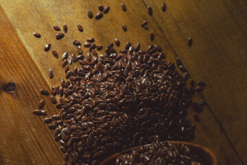 flax seeds in a wooden glass, bowl on a wooden table close-up