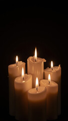 Softly glowing candles illuminate dark background, creating serene and calming atmosphere. flickering flames add warmth and tranquility