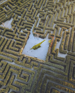 Aerial view of a sprawling maze enveloping a central plaza with dinosaur statues, creating a captivating geometric spectacle, Pe&Atilde;&plusmn;&Atilde;&shy;scola, Comunidad Valenciana, Spain.