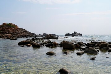 Sunlit Rocky Shoreline with Crystal Clear Ocean Water