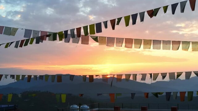 Video of Om Mani Padme Hum flags, also known as Tibetan prayer flags with the sky, clouds and sunrise in the background.