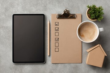 Real estate selling guide concept. Minimalist workspace with a tablet, clipboard, coffee, and plant on a textured surface.