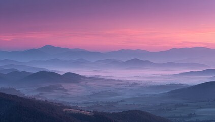 Obraz premium Misty mountain range at dawn. Sunrise hues paint the distant peaks in soft pastels. Layers of hills and valleys
