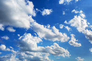 White fluffy serene clouds float across the sky giving a feeling of calm and solitude