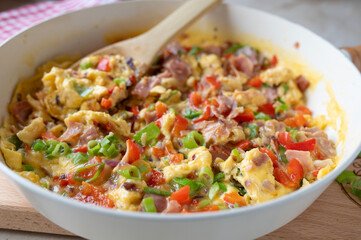 Scrambled eggs with ham and vegetables. Healthy quick breakfast, dinner or luch fresh and homemade cooked