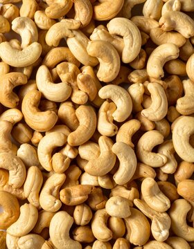Close-up of cashews, showcasing their unique shape and inviting color ideal for themes of healthy snacks, vegan recipes, or wholesome ingredients. A collection of cashews, ready to be enjoyed 