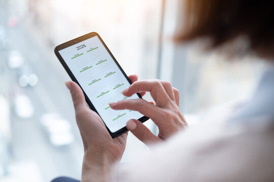 Close-Up Of A Woman Holding A Smartphone Displaying The 2026 Calendar