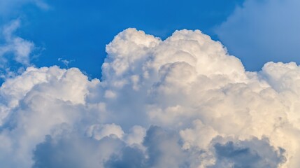 Fluffy cumulus cloud against a clear blue sky, creating a serene summer atmosphere.