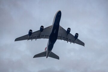 Commercial airplane flying against cloudy sky.