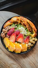 Grilled Chicken Salad Bowl with Fruits and Nuts on Wooden Table