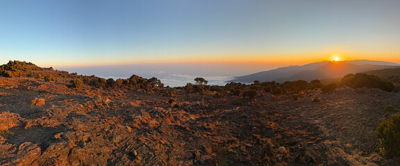 Sun is setting behind the mountains ascending kilimanjaro, tanzania