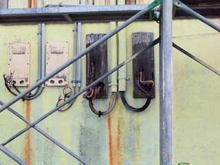 Electric cables protruding from the wall after devices have been removed.
They are for the demolition of the building, and the front steel structure is part of the scaffolding.