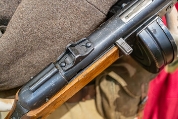 Old-fashioned rifle with long magazine held by a person, possible indoor setting