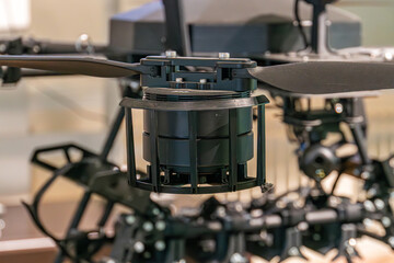 Close-up view of a Ukrainian military drone with a dark color scheme and exposed functional components, illuminated by artificial light