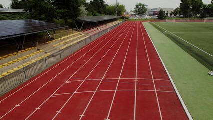 A woman runs along the track around the stadium. View from the drone