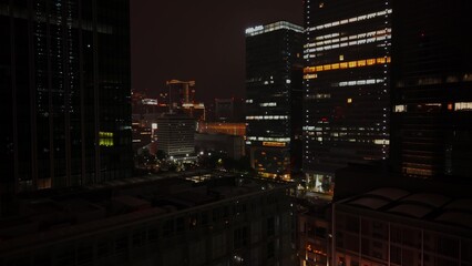 A view of a glass skyscraper from drone at night. Tokyo, Japan from a bird's eye view