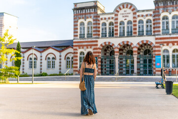 Naklejka premium Tourist walking towards thermal baths in salies de bearn, france