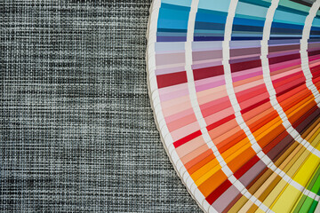 Cool toned paint swatches fan on woven fabric background for decor and color selection use