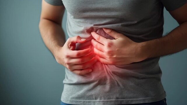 Man suffering from intolerance or food poisoning, stomach ache, abdominal pain, colon problems, gastritis, diarrhea or inflammation. Patient's hand on the belly or abdomen.