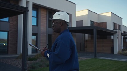 The foreman evaluates the finished object standing near the house