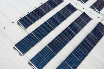 Set of solar panels on top of the concrete roof of modern building. Photovoltaic energy sources...