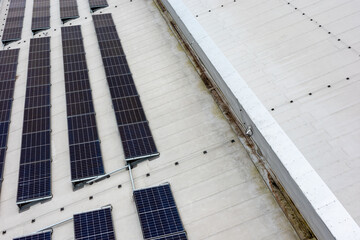 Set of solar panels on top of the concrete roof of modern building. Photovoltaic energy sources...