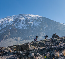 Porters  on rocky terrain in mount kilimanjaro.