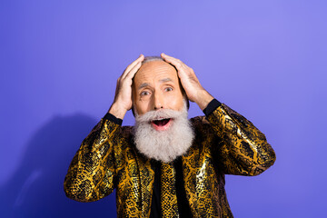 Eccentric, stylish older man with a cheerful expression wearing a striking patterned suit against a...