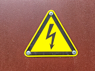 Caution symbol warning of electrical hazards on a textured background with space for additional information