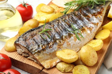 Tasty roasted mackerel with spices and vegetables on table, closeup. Homemade seafood dish