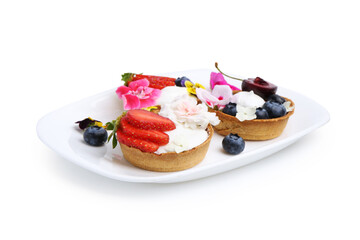 Sweet tartlets with berries and flowers isolated on white. Delicious dessert