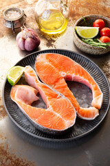 Raw salmon steak in a plate on the table, red fish, trout before cooking vertical photo