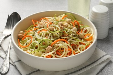 Tasty vegetable noodles with chickpeas served on grey table, closeup. Vegetarian dish