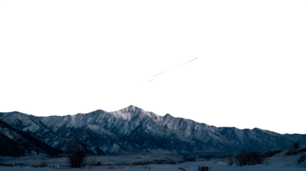 A brilliant meteor moving across a night sky above snowy mountains