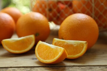 Fresh whole and cut oranges on wooden table, closeup