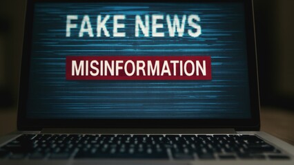 Laptop screen displaying the words "FAKE NEWS" and "MISINFORMATION" highlighting issues related to false information.