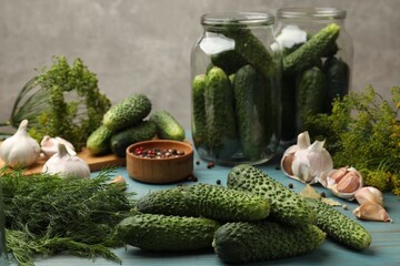 Making pickles. Fresh cucumbers and other ingredients on light blue wooden table, closeup