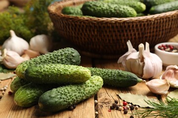 Making pickles. Fresh cucumbers and other ingredients on wooden table, closeup
