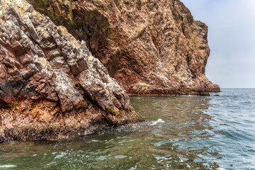 A dramatic view of the rugged coastal cliffs of the Ballestas Islands in Peru