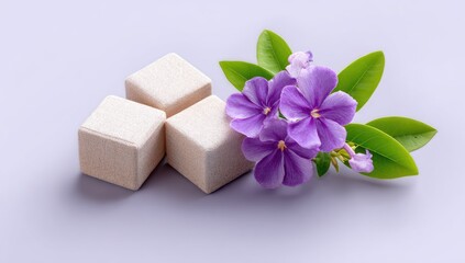Three light beige cubes with a cluster of purple flowers.