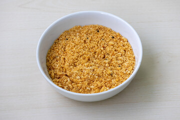 Crispy golden breadcrumbs in a white bowl on a wooden background. Perfect for baking, frying, and adding texture to savory dishes. Food photography for recipe concepts.