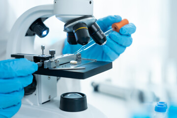 Scientist analyze biochemical samples in advanced scientific laboratory. Medical professional use microscope look microbiological developmental of viral. Biotechnology research in science lab.