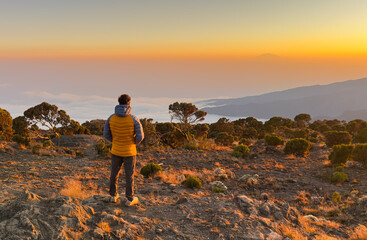 Hiker watching the sunset in mount kilimanjaro.